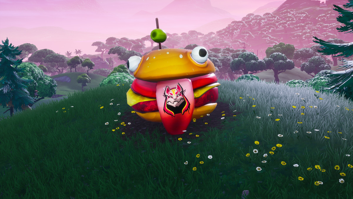 Maskot kepala burger raksasa duduk di atas bukit