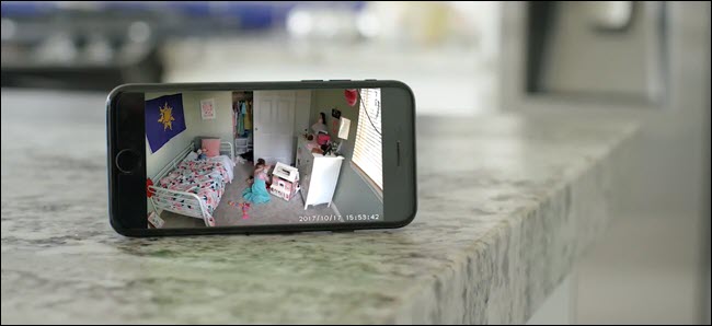 Sebuah iPhone yang memperlihatkan umpan Wyze Cam dari seorang anak yang bermain di kamarnya.
