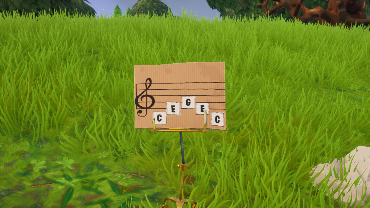 Sebuah papan nama kecil memiliki lembaran musik di atasnya dengan catatan C-E-G-E-C pada staf. 