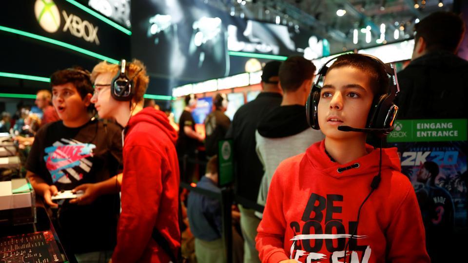 Boys play video games at the booth of Microsoft
