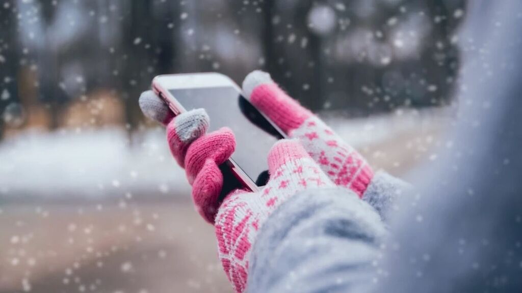 Seorang gadis menggunakan ponsel di musim dingin.