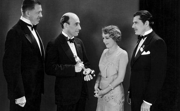 William C Demille, presidente da Academia, entrega um Oscar para Mary Pickford (ao lado de Warner Baxter, na esquerda, e Hans Kraly, direita) na primeira cerimônia de premiação do Oscar.