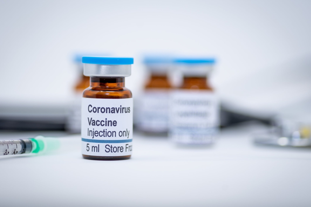 Botol dengan identifikasi yang mengatakan vaksin coronavirus, dalam bahasa Inggris.