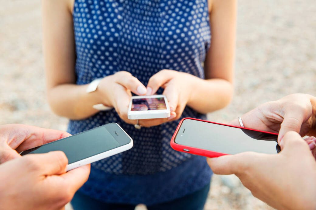 Handytarife-Vergleich: SmartGruppe mit drei Menschen, die ein Smartphone halten
