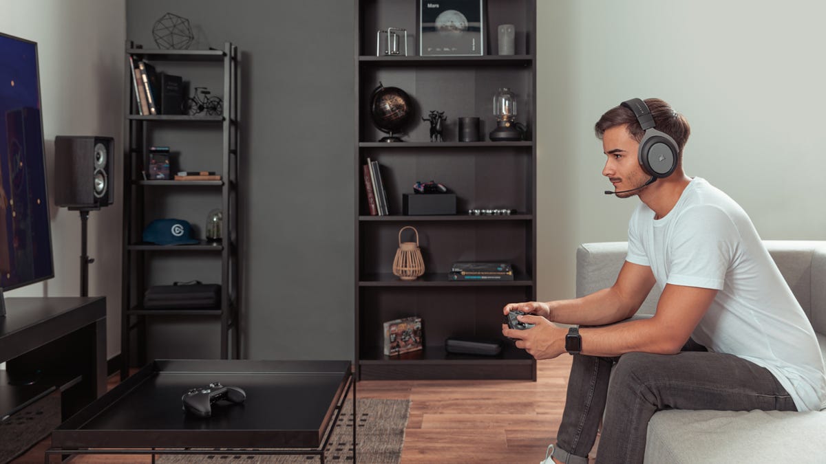 Man spelar Xbox Series X i vardagsrummet.