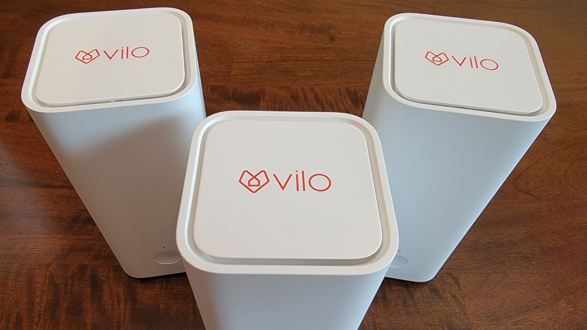 tiga perangkat wifi vilo mesh yang menampilkan logo di atas
