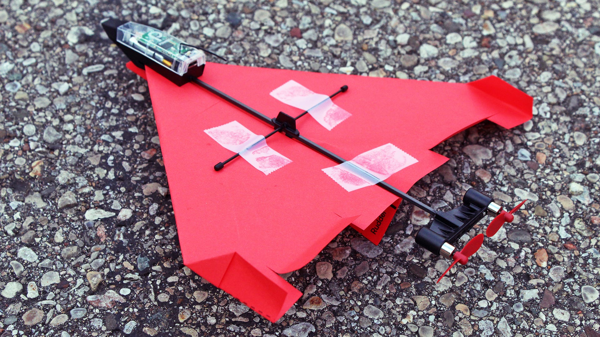 Ett pappersflygplan limmat på en RC-planliknande drönare.