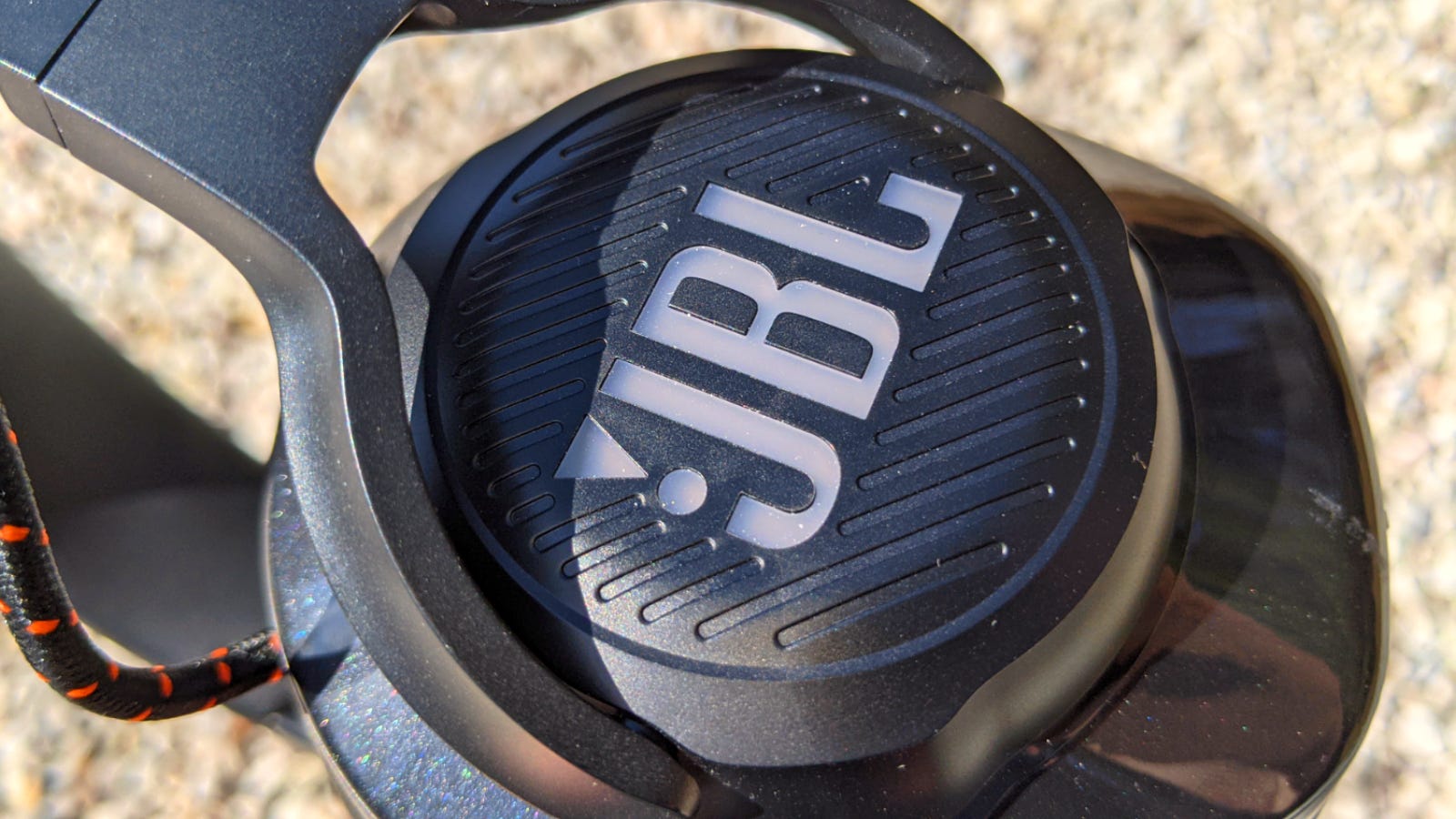 Tampilan close-up logo JBL pada penutup telinga Quantum 600. Headphone