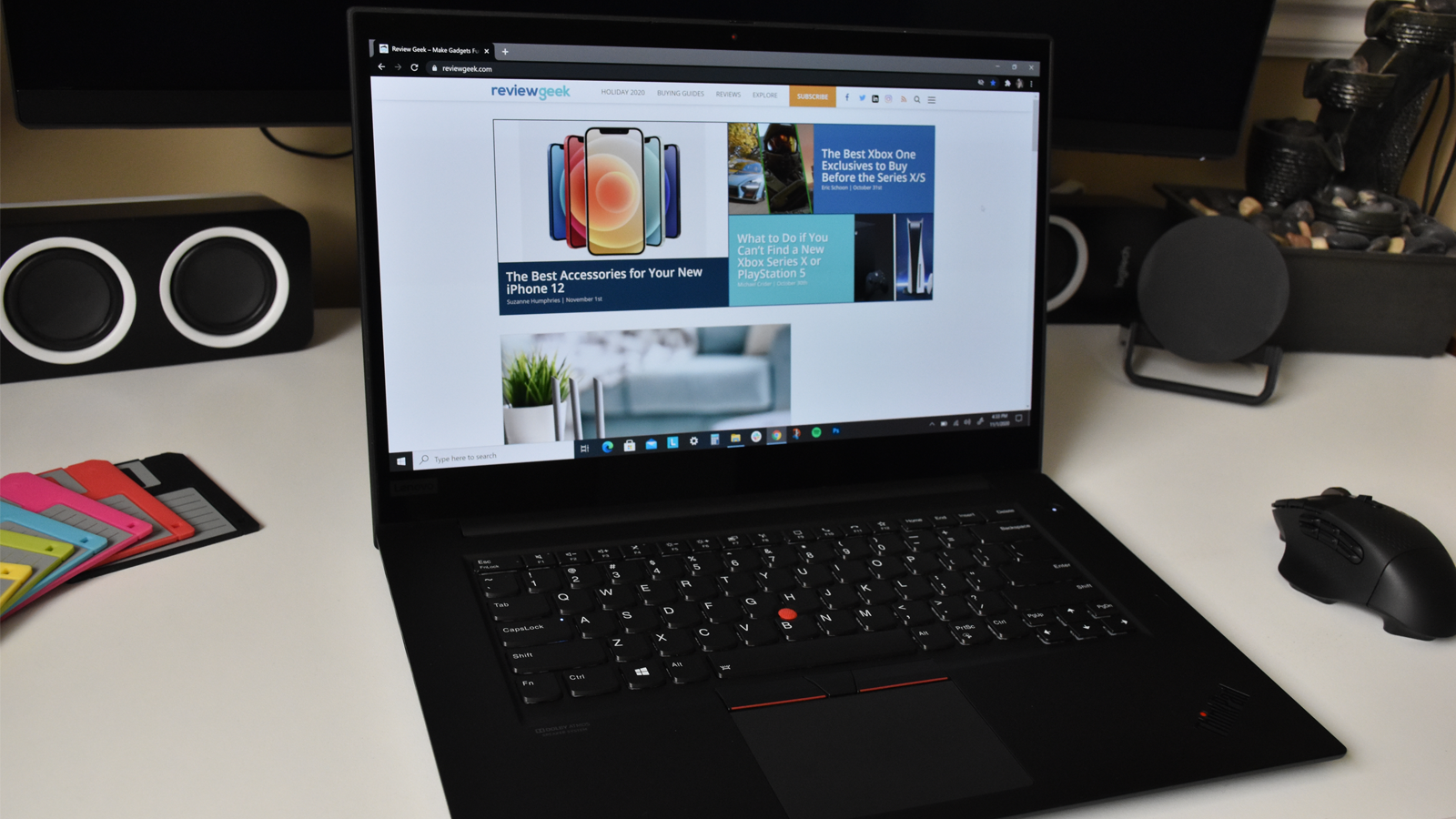 Lenovo ThinkPad X1 Extreme Gen 3 trên bàn trắng bên cạnh chuột và đế lót ly