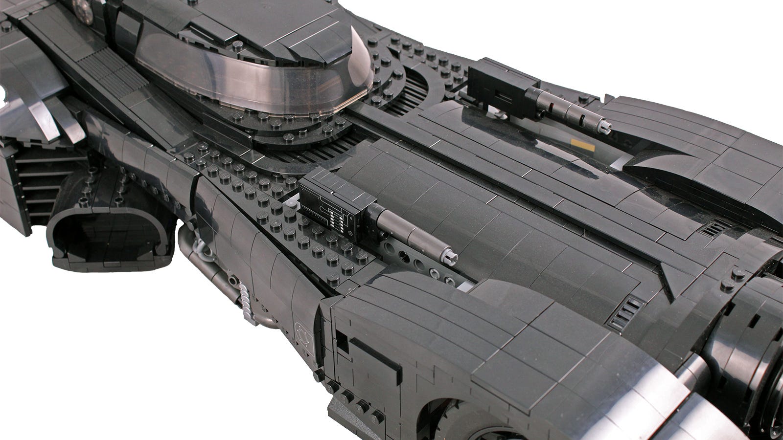 Close-up dari LEGO Batmboile dengan pistol terangkat.