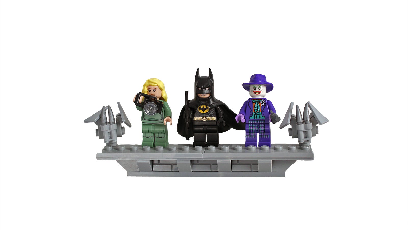 Tampilan jarak dekat dari Vicky Vale, Batman dan Joker dalam bentuk LEGO berdiri di samping gargoyle LEGO.