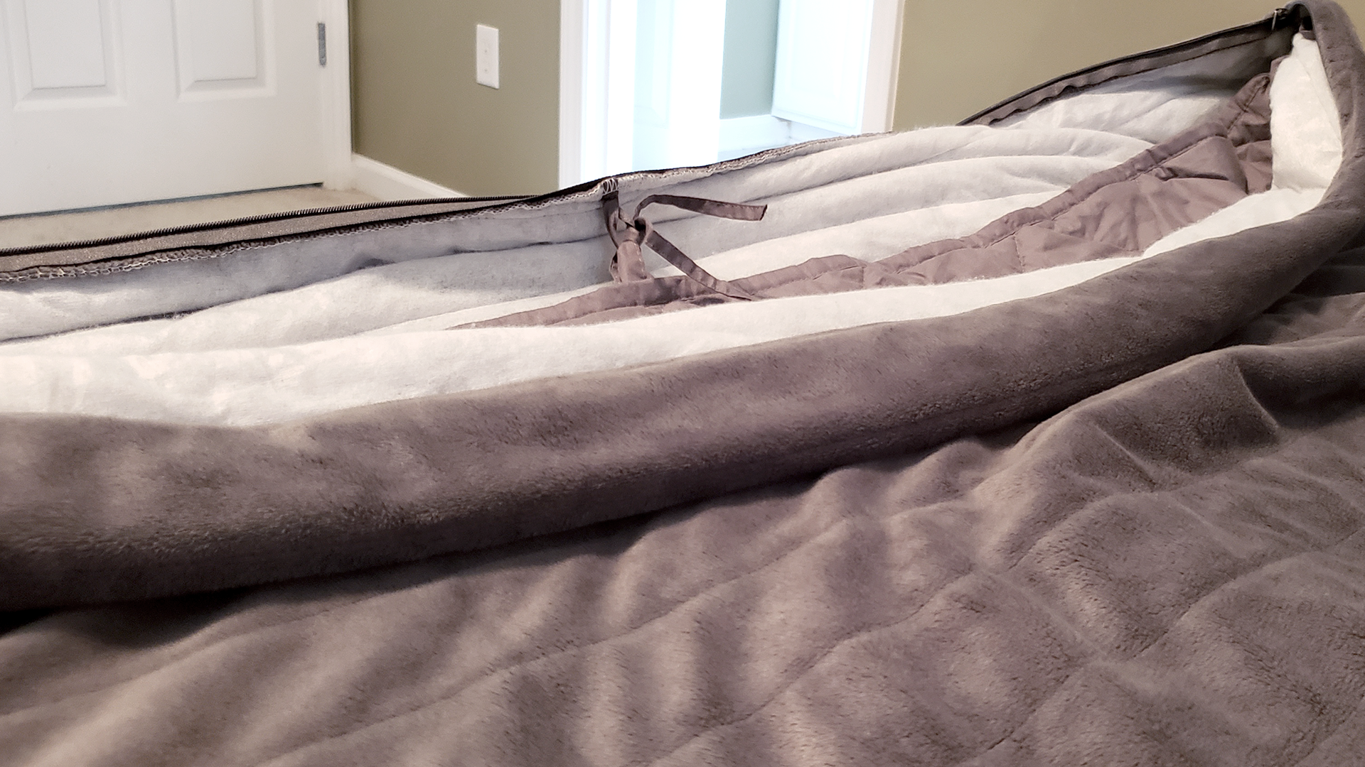 Foto sisipan berbobot di dalam selimut penutup. Ada tiga ikatan di setiap ujung selimut untuk membantu menjaganya tetap di tempatnya.