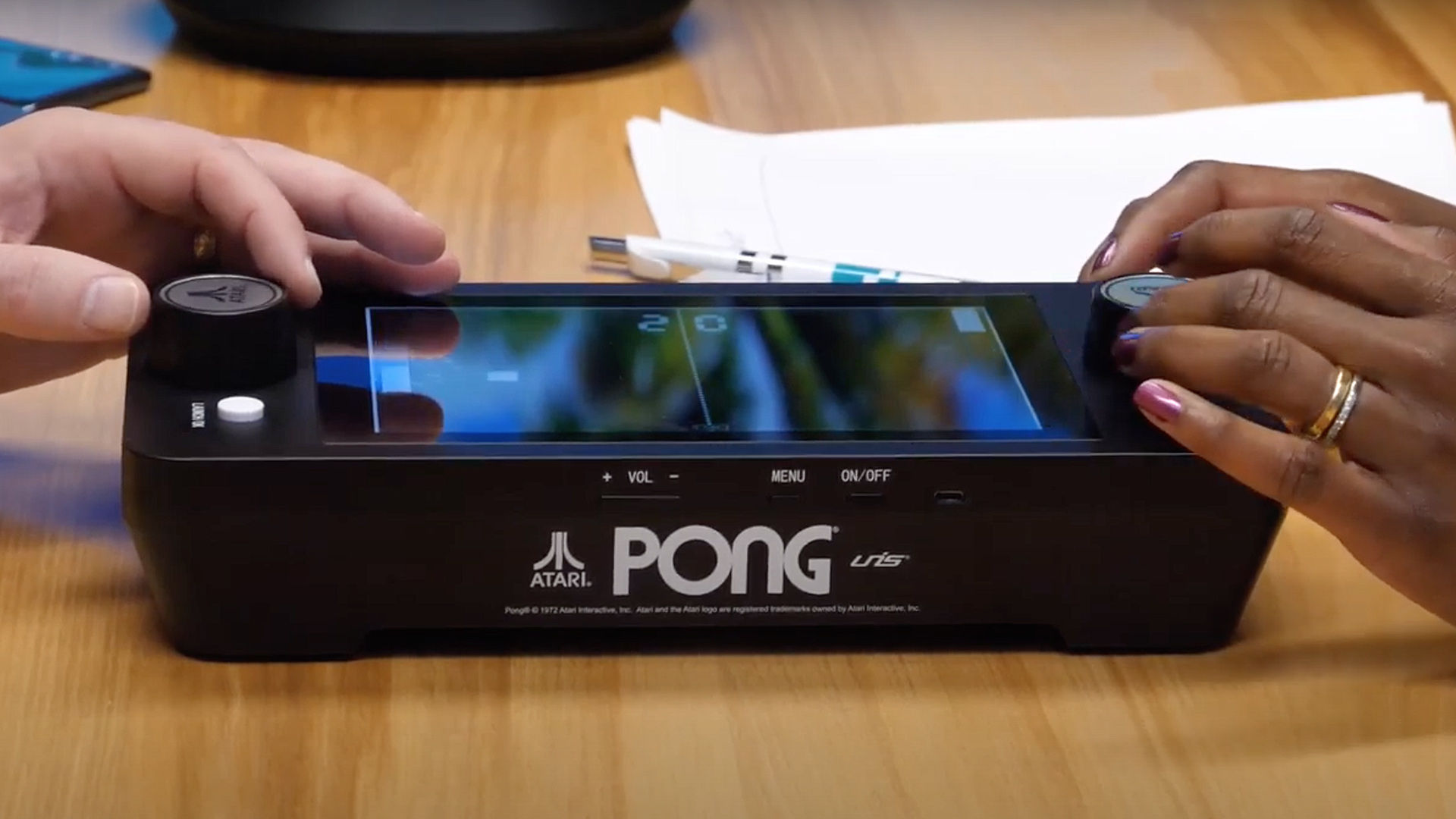 Mesin 'Pong' portabel di atas meja kopi.