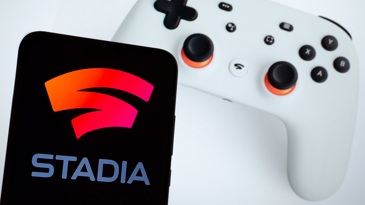 Điện thoại thông minh có logo Stadia bên cạnh bộ điều khiển trò chơi Stadia