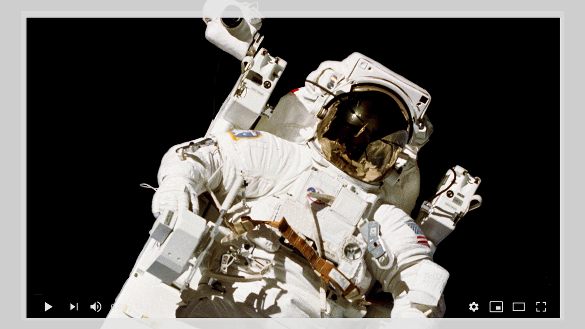 Một bức ảnh của phi hành gia Bruce McCandles II được bao quanh bởi một YouTube trình phát video.