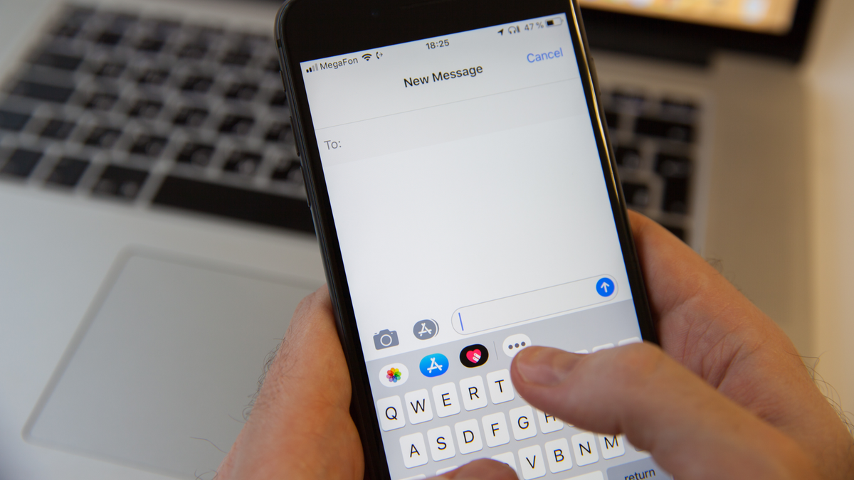 Skriv ett nytt meddelande på iPhone med MacBook i bakgrunden
