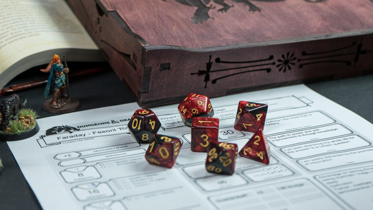 Bộ xúc xắc Dungeons & Dragons màu đỏ bằng một bảng nhân vật trò chơi và thu nhỏ