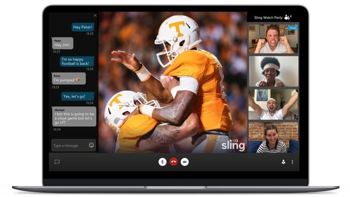 Laptop dengan pertandingan sepak bola langsung dan gambar empat orang mengobrol di layar.