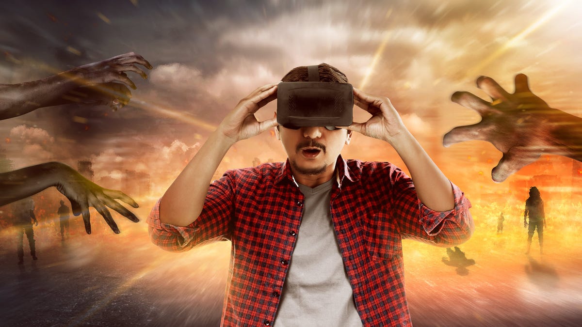 Một người đàn ông nhìn qua tai nghe VR khi những thây ma đuổi theo anh ta.