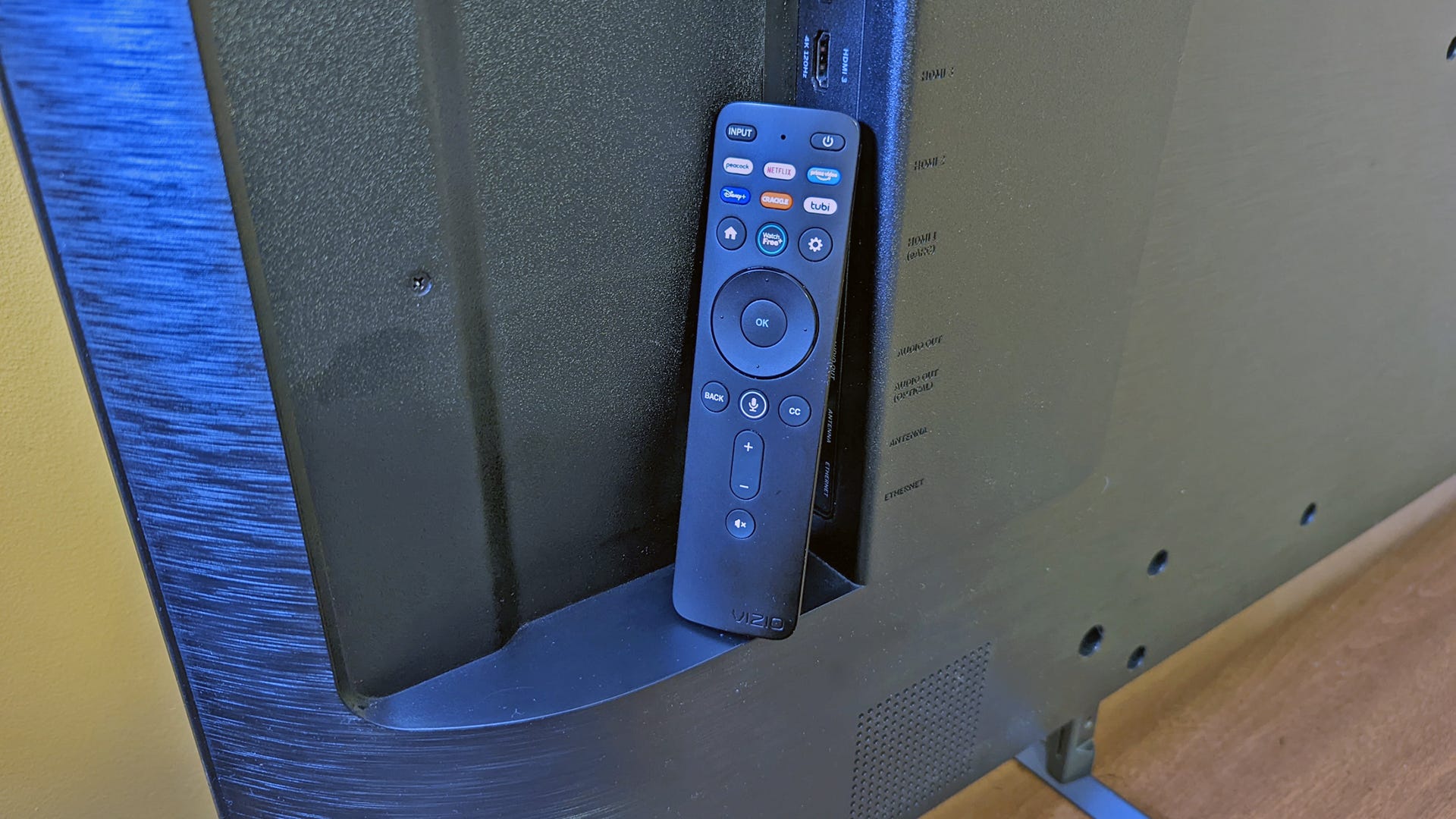 Remote control Vizio bersandar di bagian belakang TV