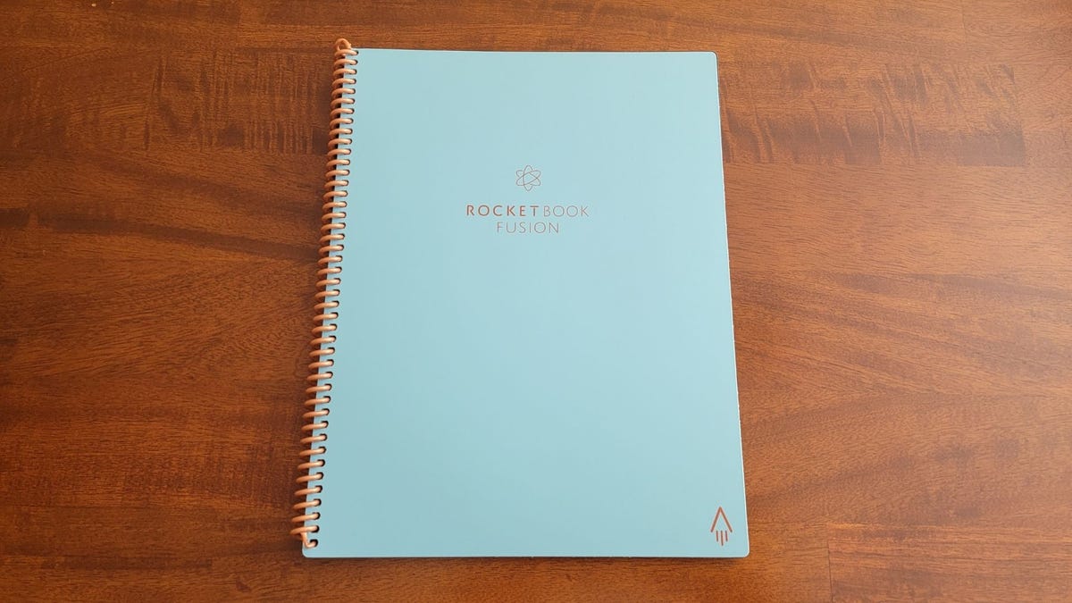 Den ljusblå Rocketbook Fusion-anteckningsboken är centrerad på ett träbord.