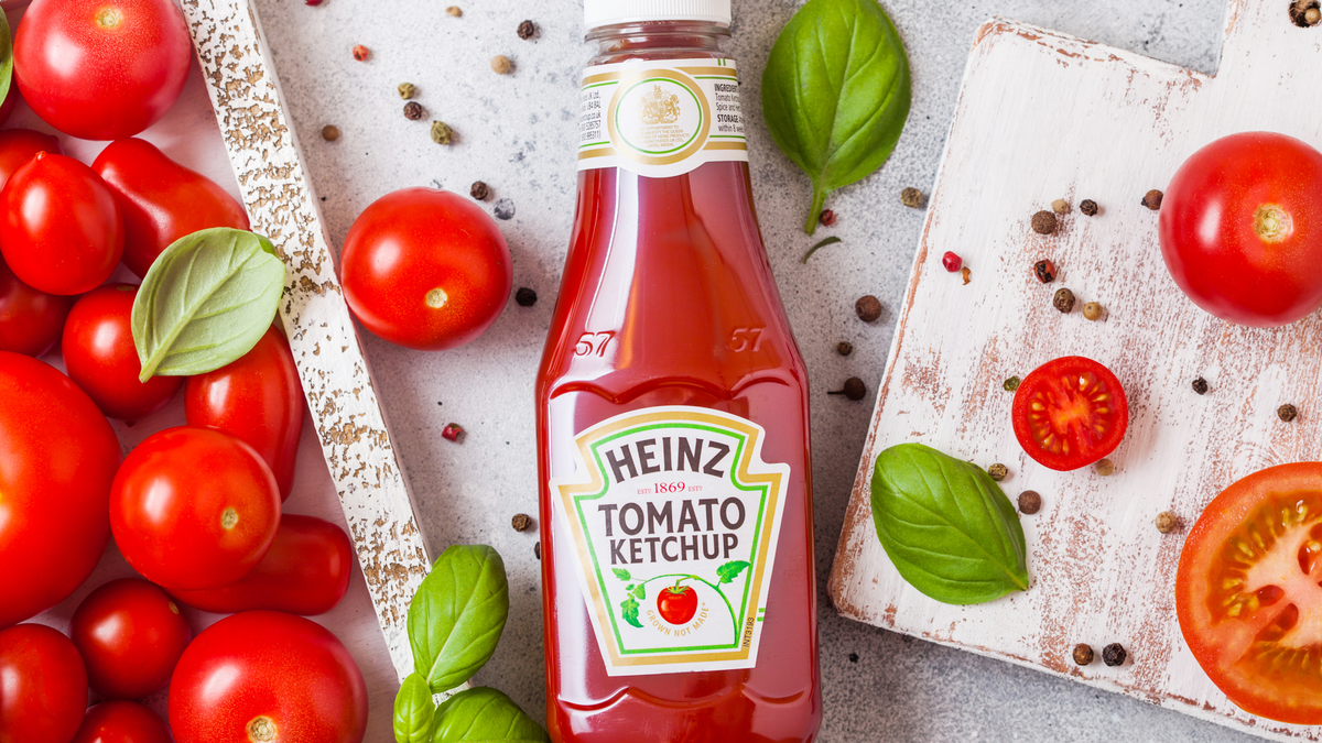 Tương cà Heinz với cà chua tươi sống trong hộp trên nền đá.