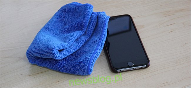 Một miếng vải sợi nhỏ màu xanh nằm cạnh một chiếc iPhone. 
